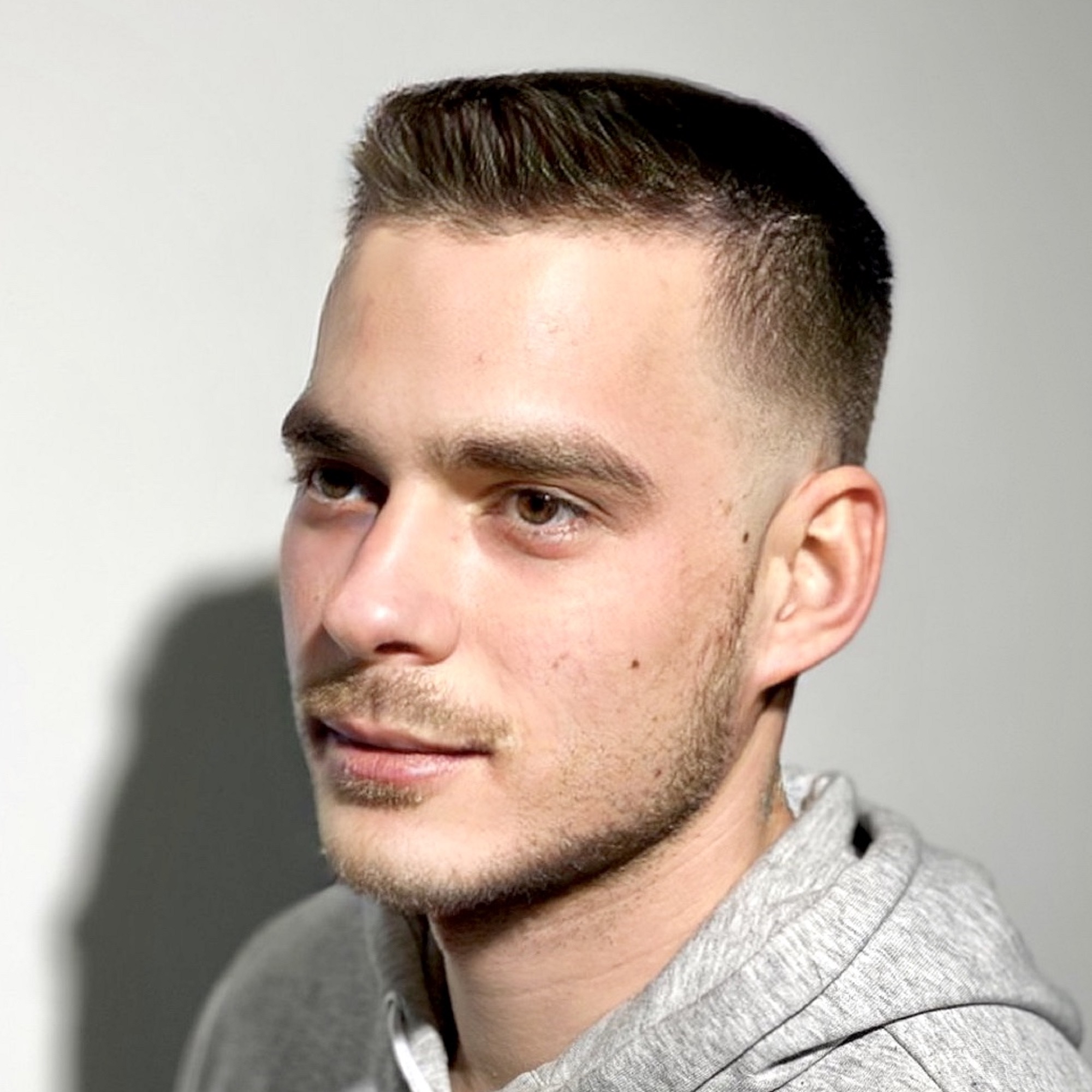 Modern fade férfi frizura hosszabb felső résszel és borotvált oldalakkal, hajvágás átmenettel