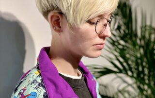 Rövid, szőke extrém pixi hajvágás elől hosszított fazonnal, fokozatos hajvágás